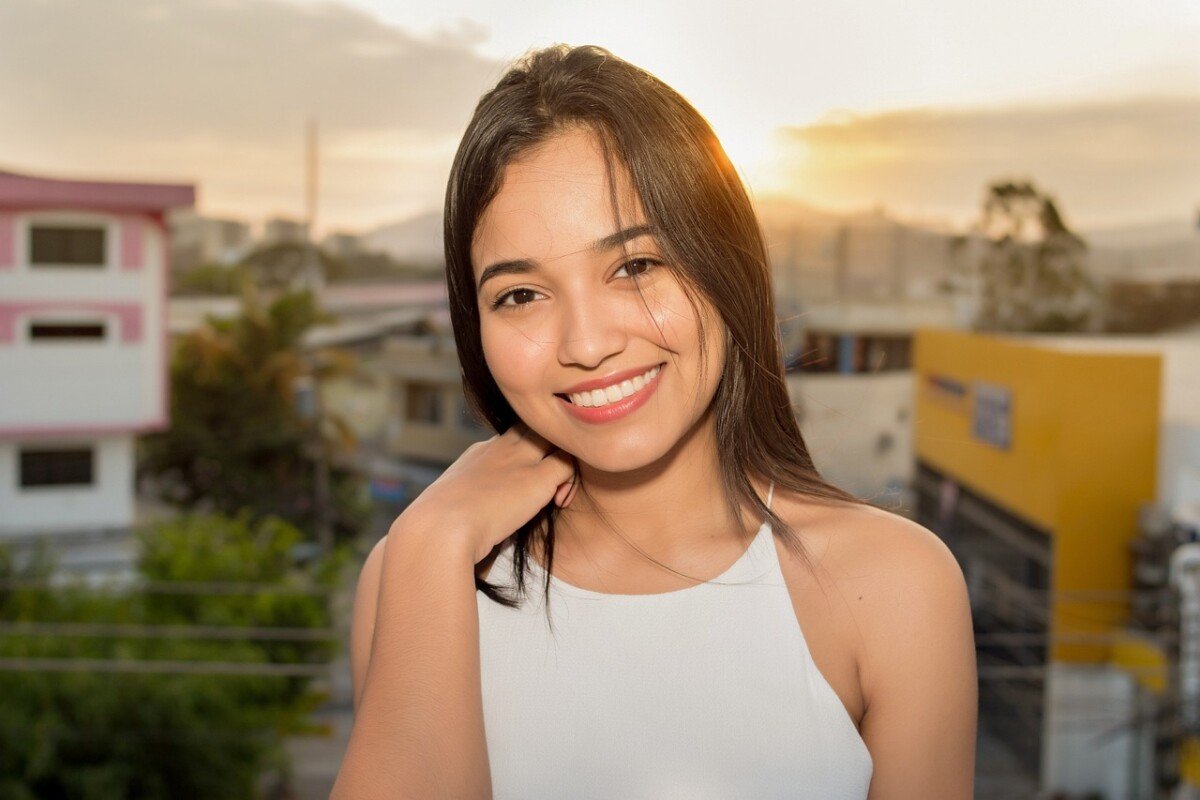 Smiling young woman in white top leaving a five-star review